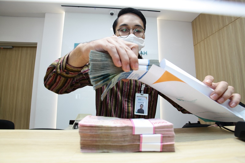 Petugas Bank Syariah Indonesia Kantor Cabang Thamrin sedang melakukan penghitungan uang kebutuhan Hari Raya Idul Fitri 1442 H, Selasa (11/5).